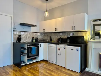 a kitchen with white cabinets and white appliances at Stylish 2BR Grassmarket Flat with Castle Views & PS5 in Edinburgh