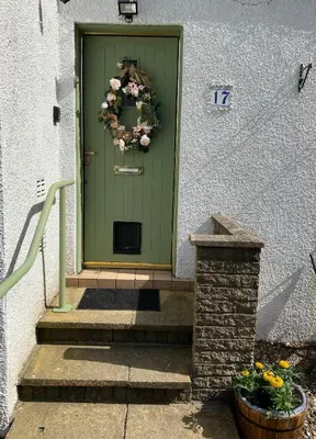 a green front door with a wreath on it at Coastal Village Property in Inverkip