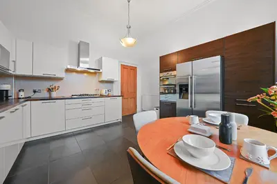 a kitchen with a wooden table and white cabinets at Merchiston 1 Room in Shared Apartment with Parking - Edinburgh in Edinburgh