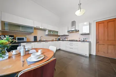 a kitchen with a wooden table and white cabinets at Merchiston 1 Room in Shared Apartment with Parking - Edinburgh in Edinburgh