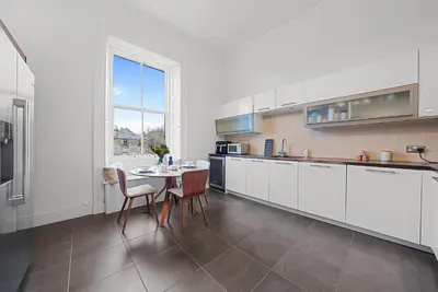a kitchen with white cabinets and a table with chairs at Merchiston 1 Room in Shared Apartment with Parking - Edinburgh in Edinburgh