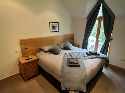 a bedroom with a large bed and a window at 6, The Gallops, Mains of Taymouth Estate, Kenmore in Kenmore