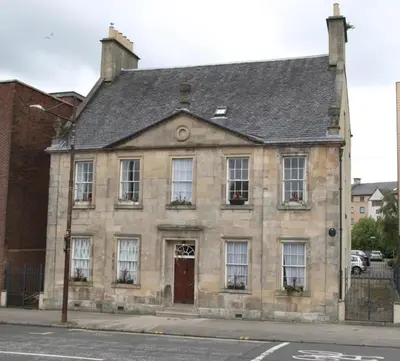 an old stone building on a city street at 52, Charlotte Street Apartments in Glasgow