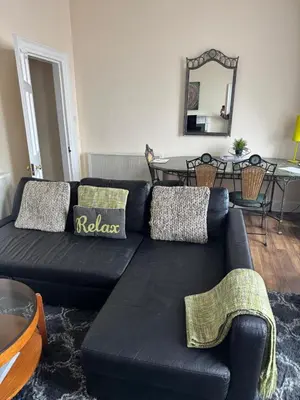 a living room with a black couch and a table at 52, Charlotte Street Apartments in Glasgow