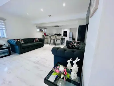 a living room with a couch and a table at Unique Modern Studio Apartment in Motherwell