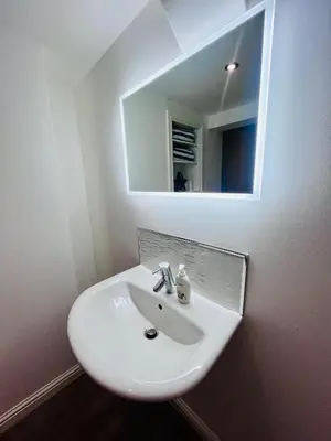 a white sink in a bathroom with a mirror at Unique Modern Studio Apartment in Motherwell