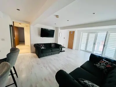 a living room with a couch and a tv at Unique Modern Studio Apartment in Motherwell