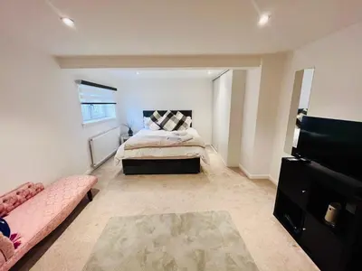 a bedroom with a bed and a couch at Unique Modern Studio Apartment in Motherwell
