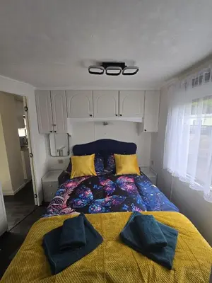 a bedroom with a bed with two pillows on it at Woodlands Retreat Holiday Home in Ballantrae