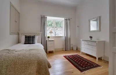 a white bedroom with a bed and a window at Mid Lodge, Penninghame Estate in Challoch