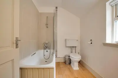 a bathroom with a bath tub and a toilet at Mid Lodge, Penninghame Estate in Challoch