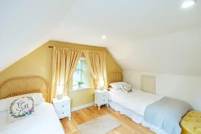 a bedroom with two beds and a window at Penninghame Estate - West Lodge in Challoch