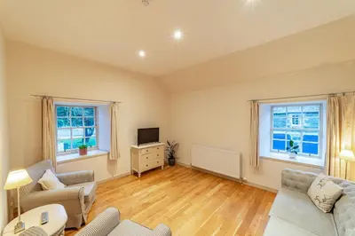a living room with a couch and a tv at Penninghame Estate - Bruce Apartment in Challoch