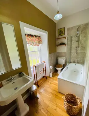 a bathroom with a sink and a tub and a toilet at Penninghame Estate- Gardeners Cottage in Challoch
