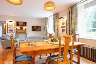a living room with a wooden table and chairs at Penninghame Estate - Earl's Library in Challoch
