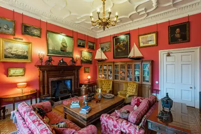 a living room with red walls and a fireplace at Penninghame Estate - Tower Apartment in Challoch
