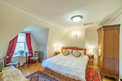 a bedroom with a bed and a table and chairs at Penninghame Estate - Tower Apartment in Challoch
