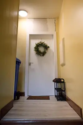 a hallway with a white door with a wreath on it at Stunning 2BR Apt - Central High Street Location in Oban