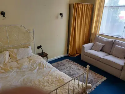 a bedroom with a bed and a couch and a window at Silverknowes in Edinburgh
