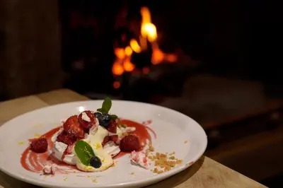 a plate of food on a table in front of a fireplace at Oyster Inn Connel in Oban