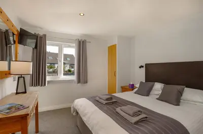 a bedroom with a bed and a desk and a window at Oyster Inn Connel in Oban