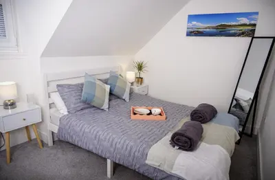 a bedroom with a bed with towels on it at Cuan Flat - Oban in Oban