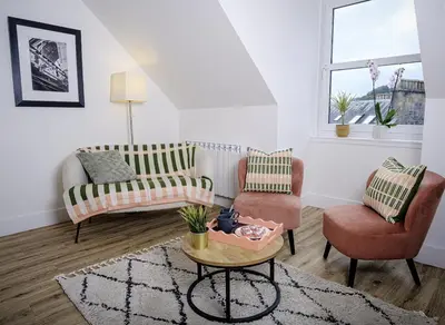 a living room with two chairs and a table at Cuan Flat - Oban in Oban