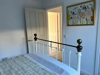 a bedroom with a bed and a door with a picture at Self-contained ground level cottage with hill view in Edinburgh
