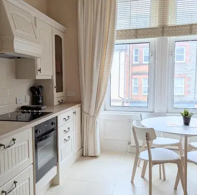 a kitchen with a table and a table and chairs at Kirk street apartment in Campbeltown