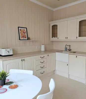 a kitchen with white cabinets and a table and chairs at Kirk street apartment in Campbeltown