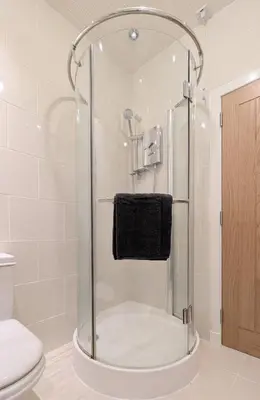 a shower with a glass door in a bathroom at Kirk street apartment in Campbeltown