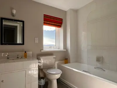 a bathroom with a toilet and a tub and a sink at Kilfinan Hotel in Kilfinan