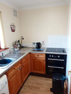 a kitchen with a sink and a stove top oven at Lochside Cottage Glencoe