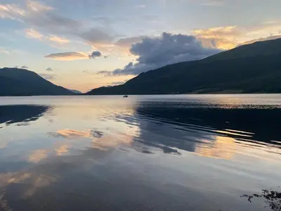 a large body of water with mountains in the background at Lochside Cottage Glencoe