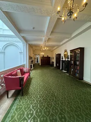 a living room with a pink couch on a green carpet at The South Wing in Acharn
