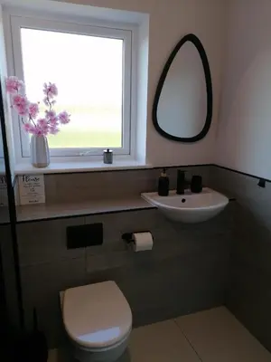 a bathroom with a toilet and a sink and a mirror at Entire Spacious 3-Bed Family Home, City Centre, Free Parking, Garden in Glasgow