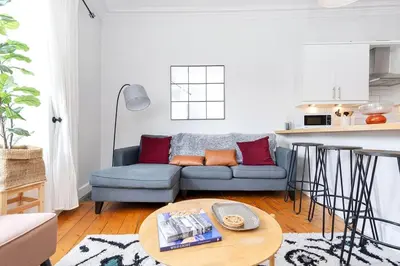 a living room with a blue couch and a table at GuestReady - Modern 1BR in Edinburgh in Edinburgh