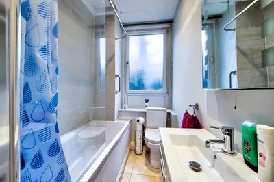 a bathroom with a tub and a toilet and a sink at Edinburgh Drumdryan Central Apart in Edinburgh