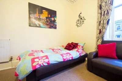 a bedroom with a bed and a couch at Edinburgh Central Morrison Apartment in Edinburgh