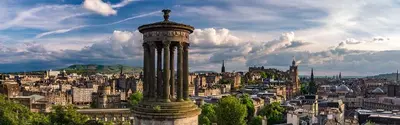 a view of a city with a statue on top of a building at Edinburgh Central Morrison Apartment in Edinburgh