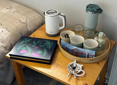 a table with a coffee maker and cups on it at Edinburgh Home from Home in Edinburgh