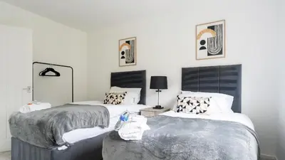 a bedroom with two beds and a mirror at Craigseaton House in Broxburn