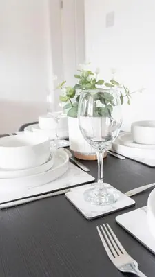 a table with white plates and a wine glass at Craigseaton House in Broxburn