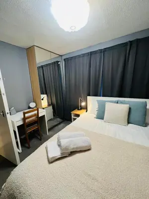 a bedroom with a large bed with a blue wall at Bank West in Edinburgh