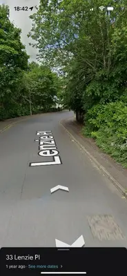 an empty road with white arrows on the road at Superb Homestay in Cowlairs
