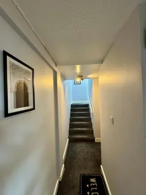 a hallway with stairs with a picture on the wall at Superb Homestay in Cowlairs