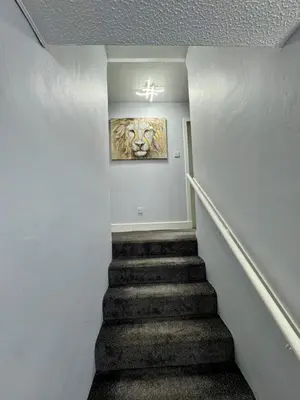 a staircase with a painting of a tiger on the wall at Superb Homestay in Cowlairs