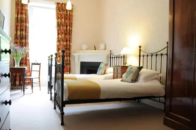 a bedroom with two beds and a fireplace at The Billiard Room Flat