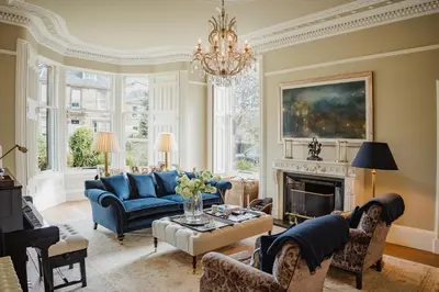 a living room with a blue couch and a fireplace at Private and Prestigious Luxury Home in Edinburgh