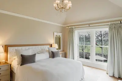 a bedroom with a white bed and a window at Private and Prestigious Luxury Home in Edinburgh